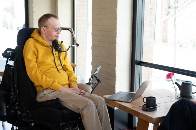 Man with limited motion ability looks at laptop