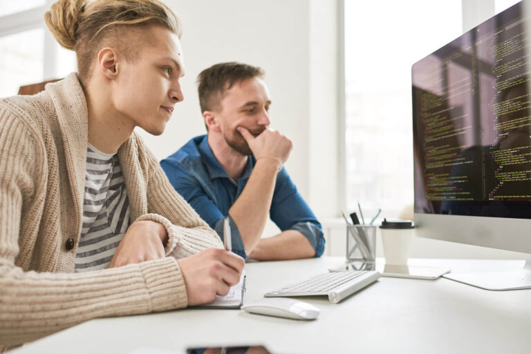 Two QA engineers collaborating at work stations