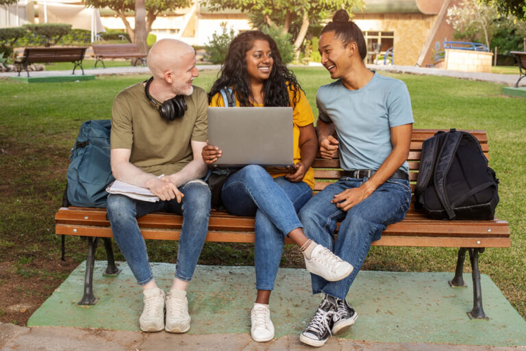 Cheerful college students sitting on a bench