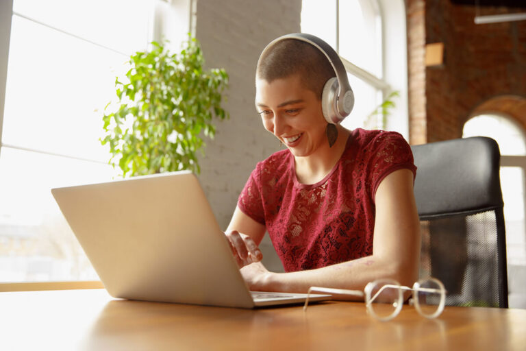 Smiling person sitting at desk with headphones on